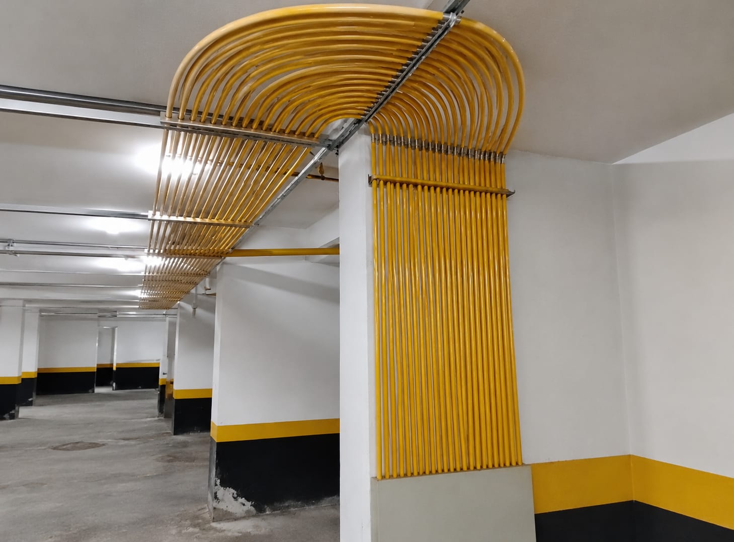 Prumadas de tubulação de gás em cobre pintado instaladas em garagem de edifício